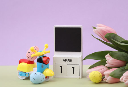happy easter. Calendar with date april 11, tulips, easter eggs and moped on pastel backgroundの写真素材