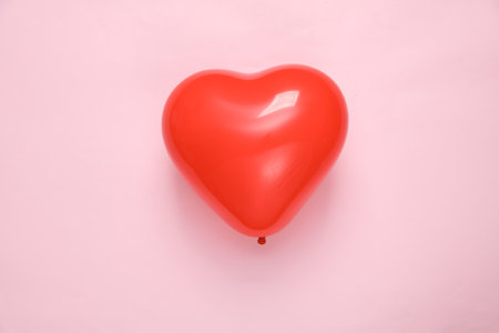 Red balloon in the shape of a heart on a pink background. Valentine's Dayの写真素材