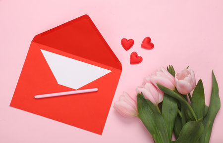 Bouquet of pink tulips and red envelope with hearts on a pink background. love concept. top view