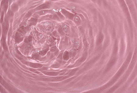 Pink water surface with rings and ripples. Spa concept background.の写真素材