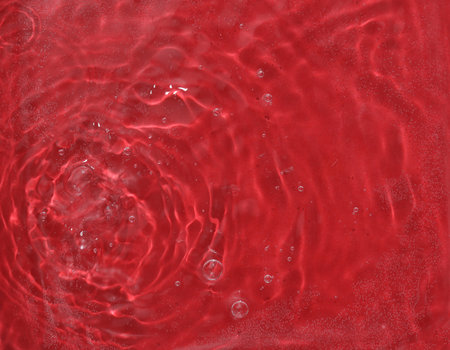 Red water surface with rings and ripples. Spa concept background.の写真素材