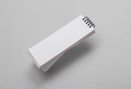 Open thin notebook levitating on a gray background