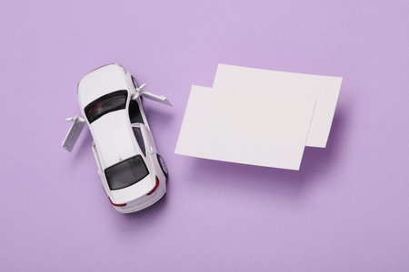 White Blank business cards for branding and toy car on purple background. Creative Mockup for presentations and corporate identity. top viewの写真素材