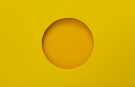 Round hole in paper, yellow backgroundの写真素材