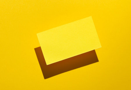 Yelow Blank business card for corporate identity with shadow on yellow background. creative mockup.の写真素材