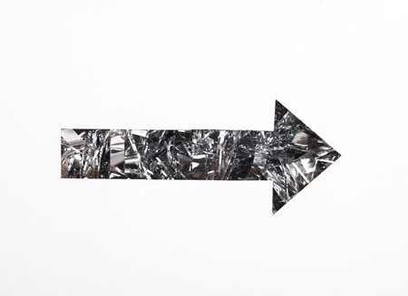 Index arrow cut out of paper hole with tinsel on white backgroundの写真素材