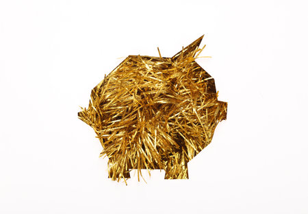 Piggy bank cut out of paper hole with golden tinsel on white backgroundの写真素材