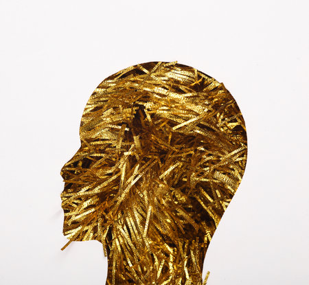 Human head cut out of paper hole with golden tinsel on white backgroundの写真素材