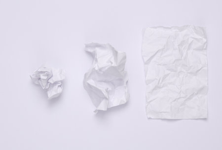 Step by step process of crumpling paper into a ball on a white backgroundの写真素材