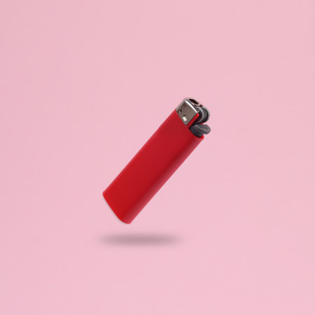 Red lighter levitating on pink background with shadowの写真素材
