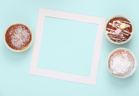 Cupcakes with a white empty frame on a blue background. top viewの写真素材