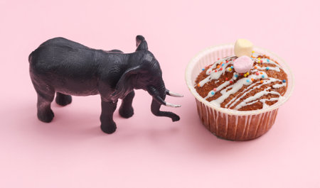 Toy elephant with muffin on pink backgroundの写真素材