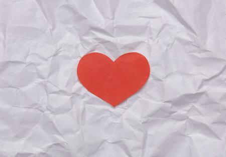 Red paper cut heart on crumpled paper. love conceptの写真素材