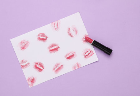 Lip print left by lipstick on white paper and lipstick on pastel background. Valentine's day concept. top viewの写真素材