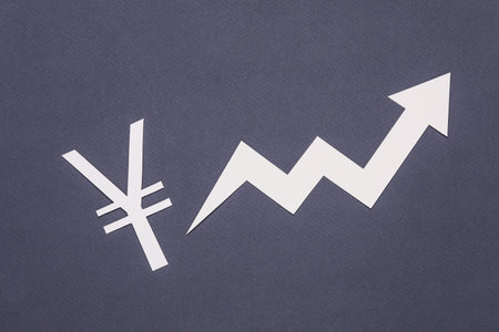 Yuan symbol cut out of paper with a growth arrow on a gray background. finance conceptの写真素材