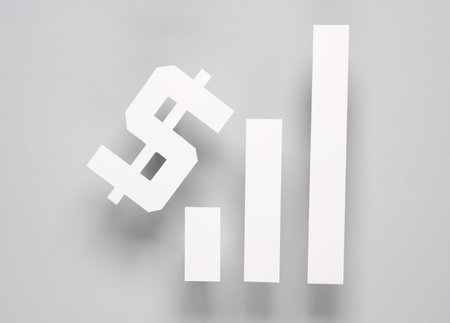 Paper-cut columns of a chart tending upwards and dollar symbol on a gray background. Analytics, business conceptの写真素材