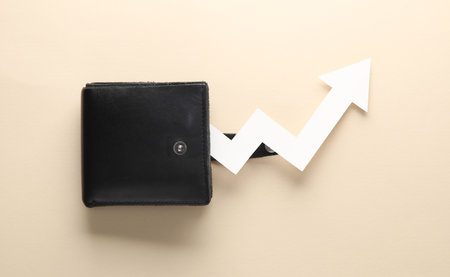 Leather purse with growth arrow on beige backgroundの写真素材