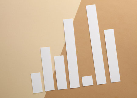 Paper-cut columns of a chart on brown background. Economic growth, analytics, business conceptの写真素材