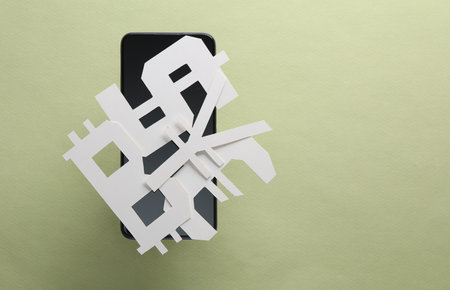 Different paper cut currency icons with smartphone on green backgroundの写真素材