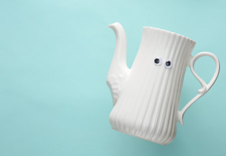 Ceramic teapot with eyes on a blue backgroundの写真素材