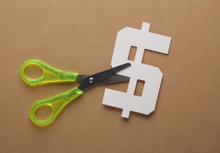 Scissors cut paper dollar icon on brown backgroundの写真素材