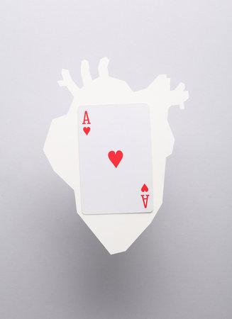 Paper-cut heart with ace of hearts card on gray backgroundの写真素材