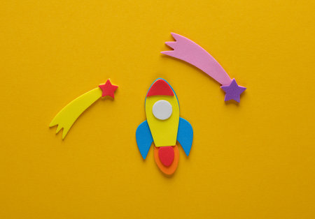 Rocket with camets on a yellow background. space exploration. children's creativityの写真素材
