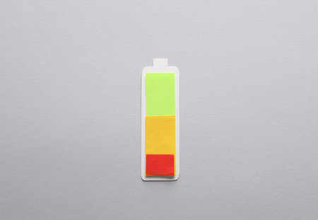 Paper-cut battery with different charge levels on a gray background