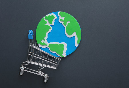 Mini supermarket trolley with planet earth on a gray background. global shoppingの写真素材