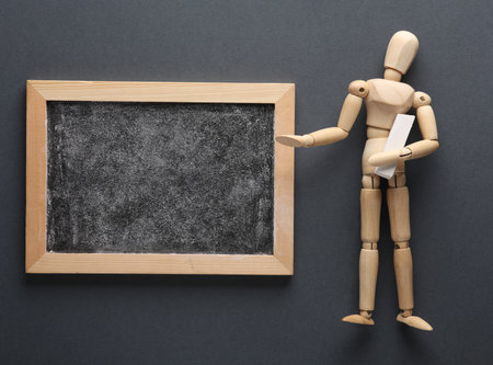Chalk board with marionette on gray background. Business training, education conceptの写真素材