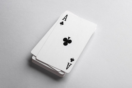 Ace of clubs on a stack of playing cards, gray backgroundの写真素材