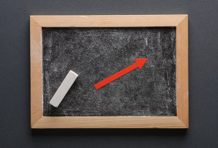 Chalkboard and red arrow on a gray background. business conceptの写真素材