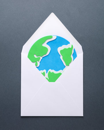 Envelope with the planet earth on a gray background