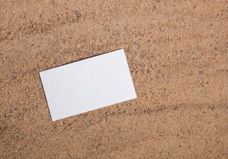 Corporate identification for a travel company. White empty business card on sand. Top viewの写真素材