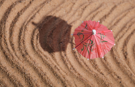 Beach vacation. Unbrella on sand with shadow. Top viewの写真素材