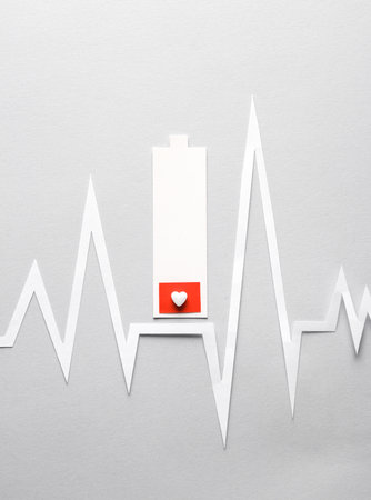 heart disease. Paper cut low battery and heart rate cardiogram on gray backgroundの写真素材