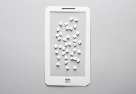Paper-cut smarton with a lot of hearts on a gray background. Followers, love conceptの写真素材