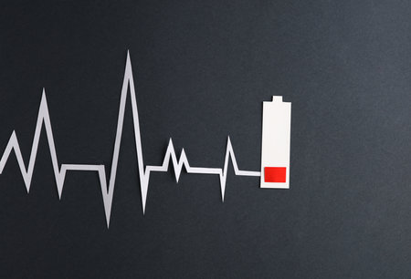 heart disease. Paper cut low battery and heart rate cardiogram on dark gray backgroundの写真素材