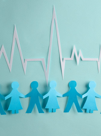 People Chain with a cardiological heart rhythm cut out of paper on blue background. Nation health