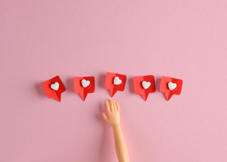 Doll's hand with Social media likes on pink background. creative minimal layoutの写真素材