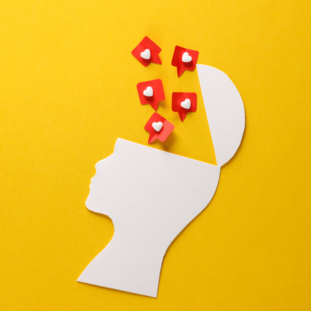 Paper cut head silhouette with likes on yellow background. Social Media Addiction
