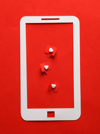 Paper cut smartphone with Social media likes on red background. creative minimal layoutの写真素材