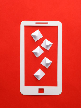 Paper-cut smartphone with envelopes on a red background.の写真素材