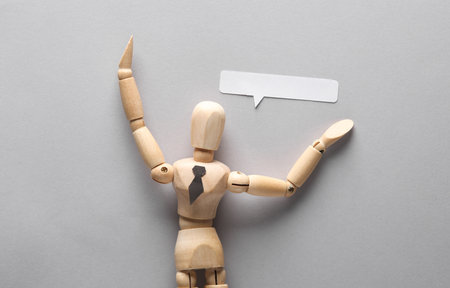 Businessman puppet with speech bubble on gray backgroundの写真素材