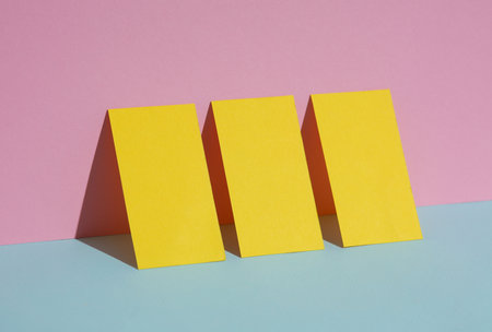 Yellow blank business cards on a blue-pink pastel background. creative minimal layout. corporate identityの写真素材
