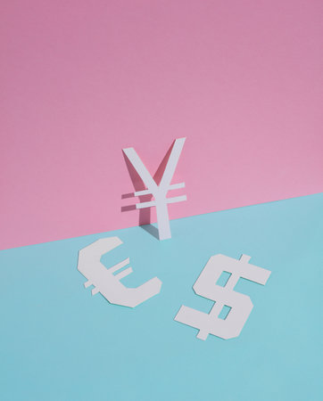 Different signs of currencies cut out of paper on a blue-pink backgroundの写真素材