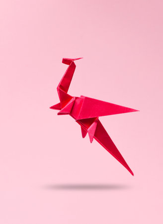 Origami dragon levitating on a pink backgroundの写真素材