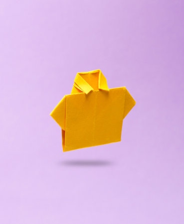 Yellow origami shirt levitating on purple backgroundの写真素材