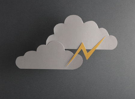 Paper-cut gray clouds with lightning on a gray backgroundの写真素材