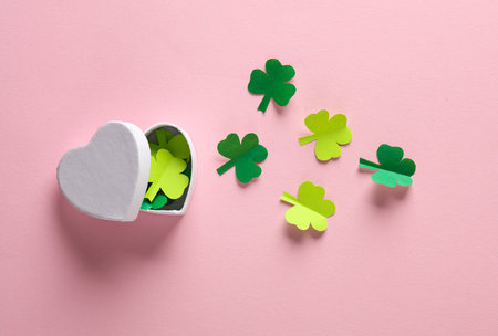 Heart shaped box with clover leaves on pink backgroundの写真素材